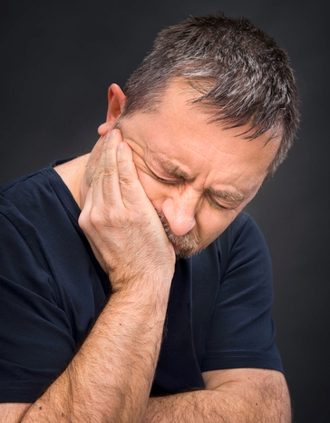 Toothache. Man with face closed by hand